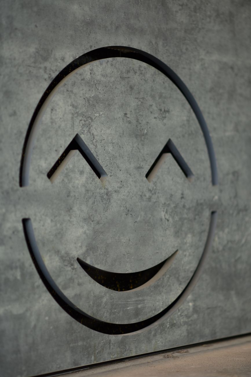 carved stone smiley face on textured background