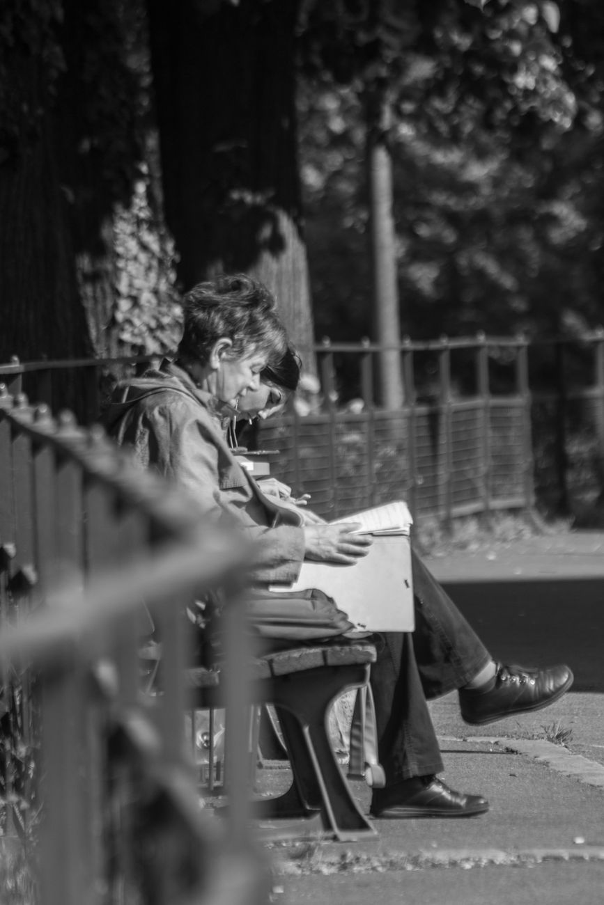 grayscale photo of man and woman sitting on bench