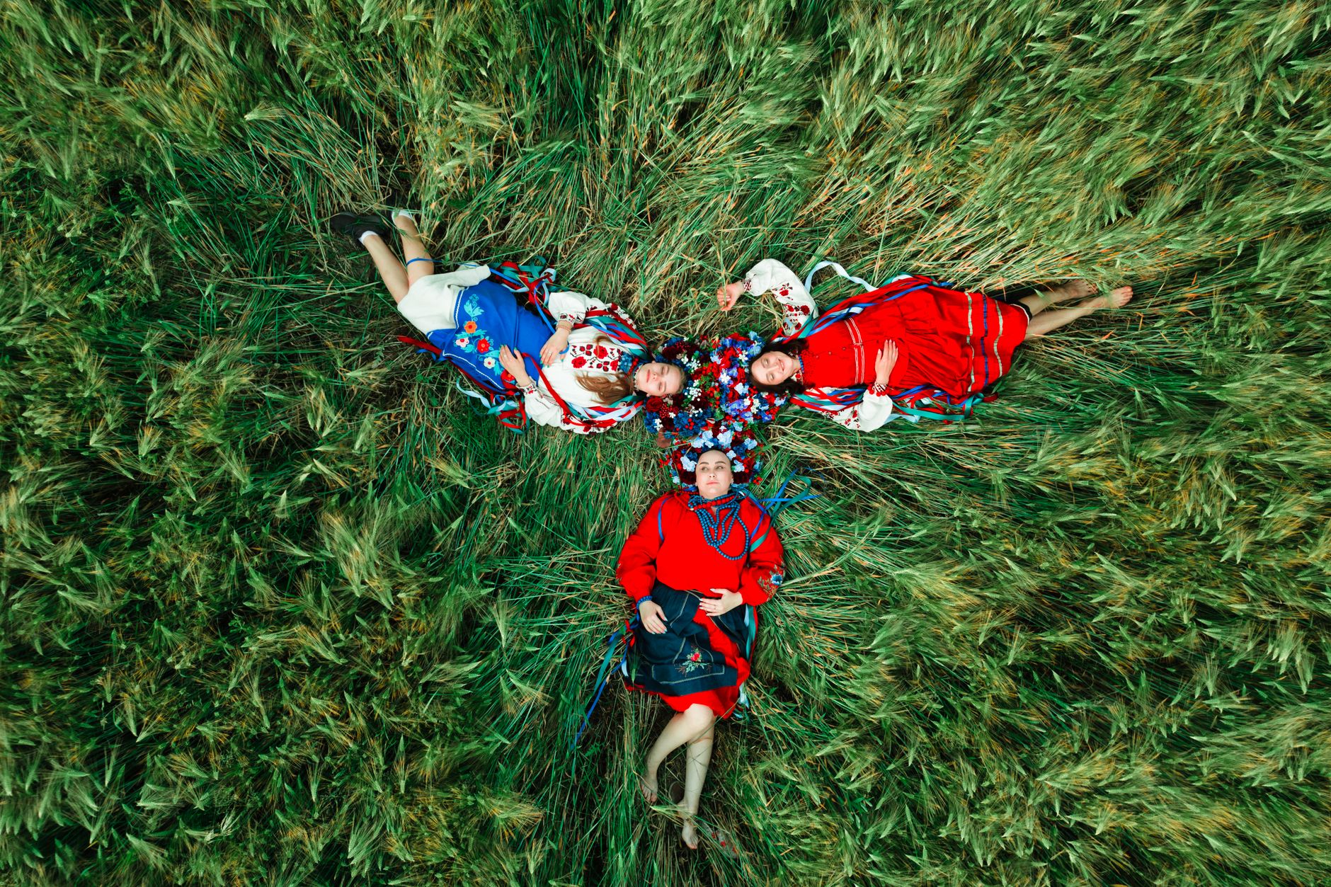 women lying down on a grass field