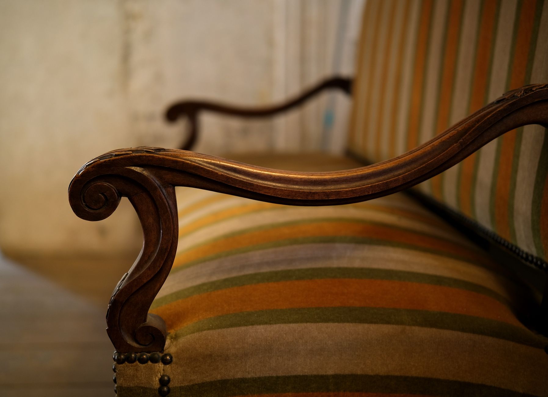 close up of vintage striped armchair armrest