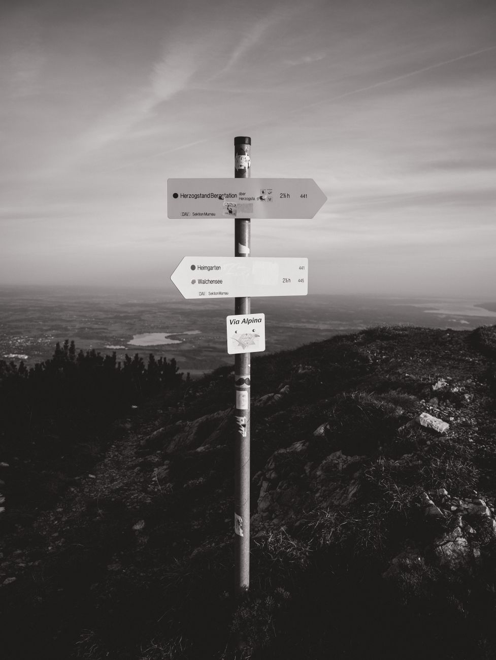 scenic mountain path with signpost at sunrise