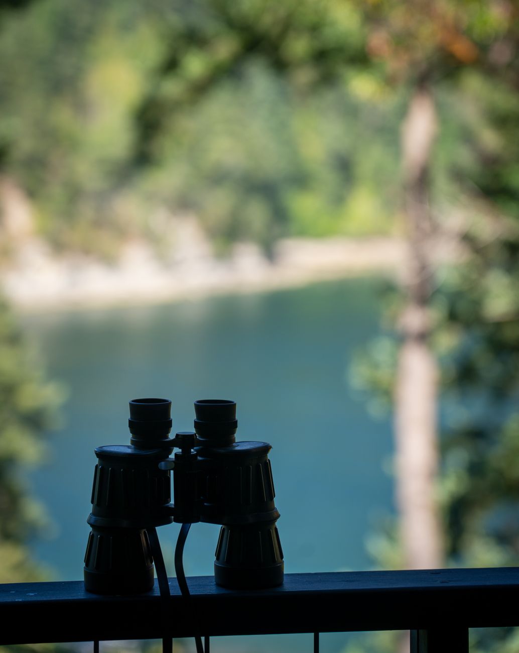 close up of binoculars standing on a balustrade of a balcony