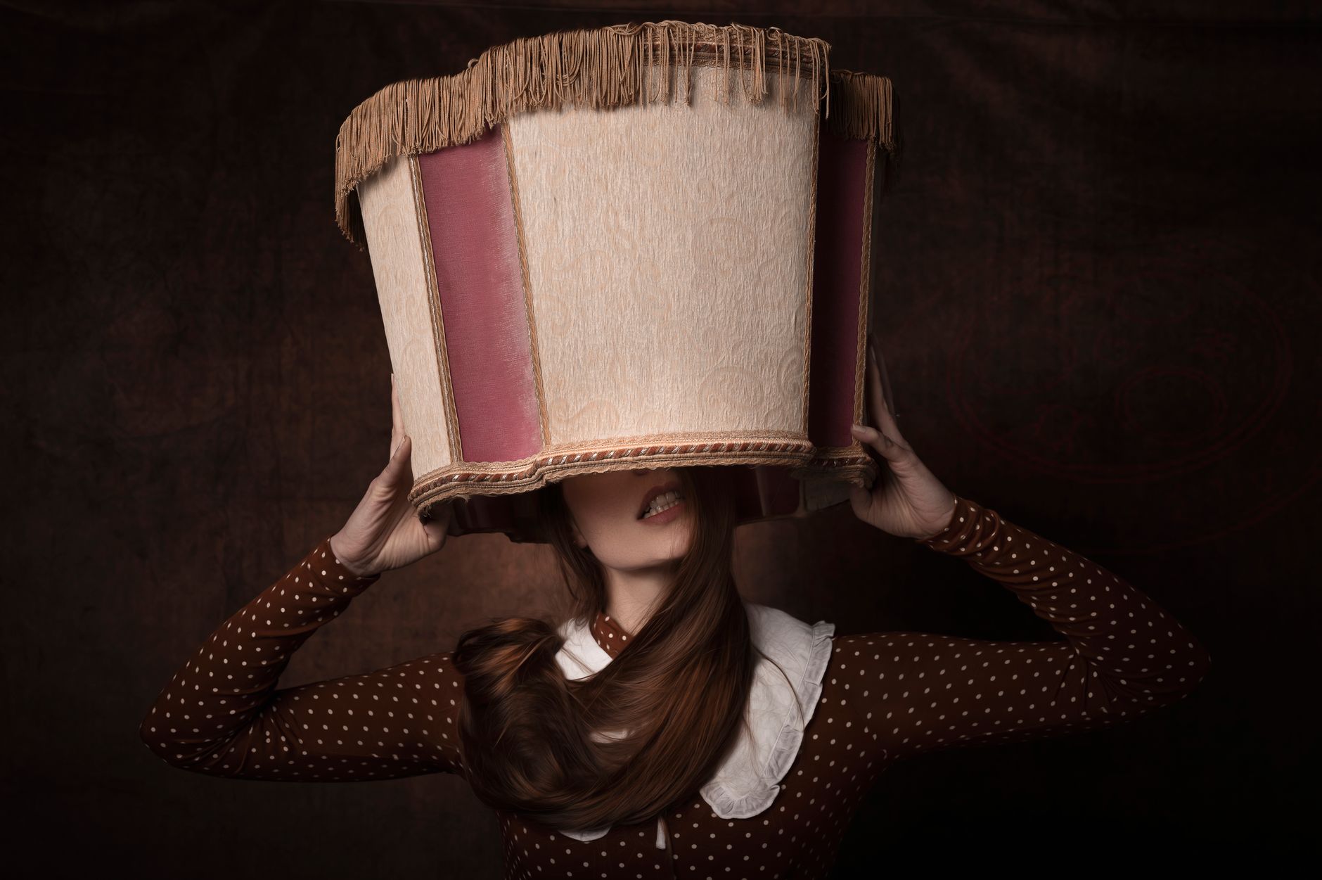 a person covering her head a lampshade cover
