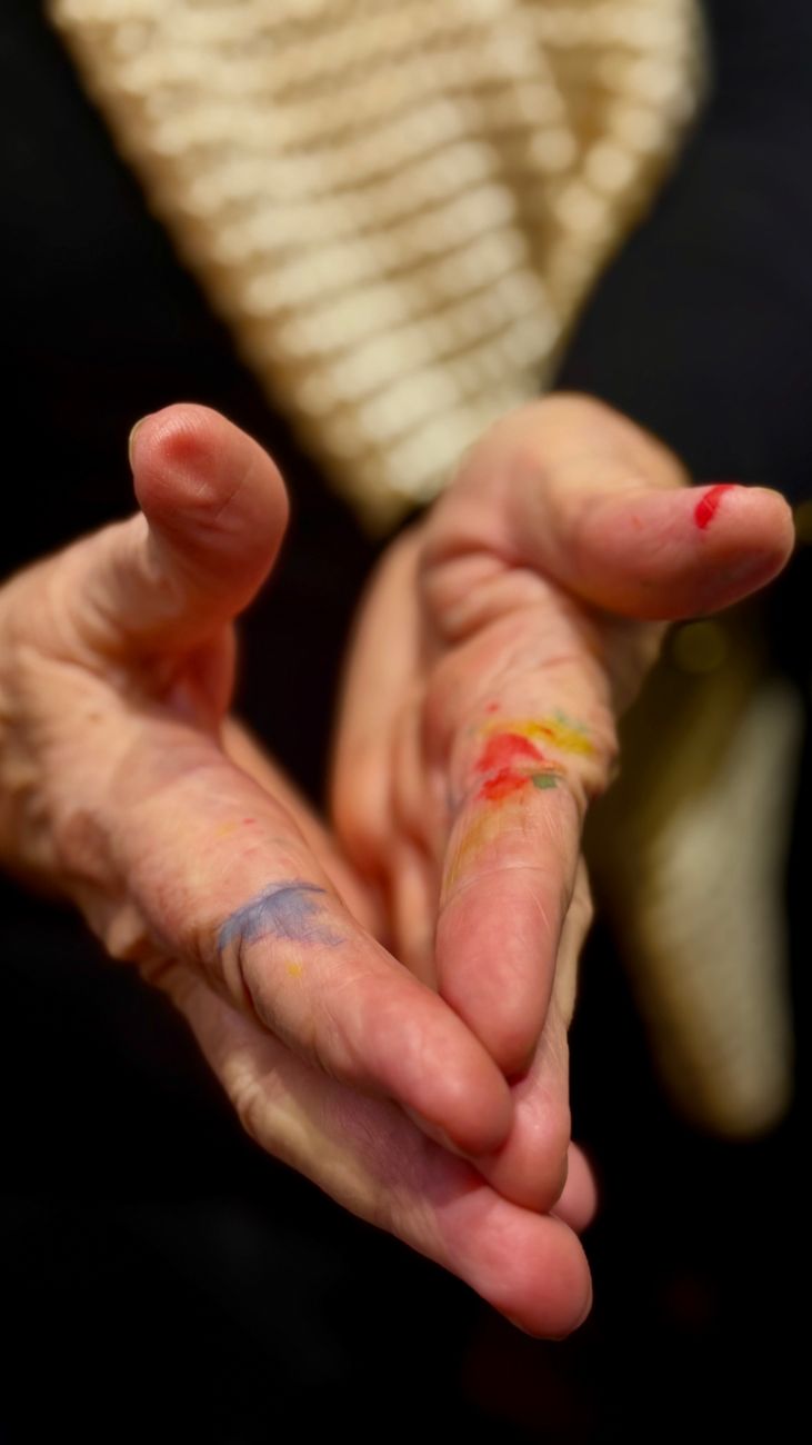 colorful paint on elderly hands close up