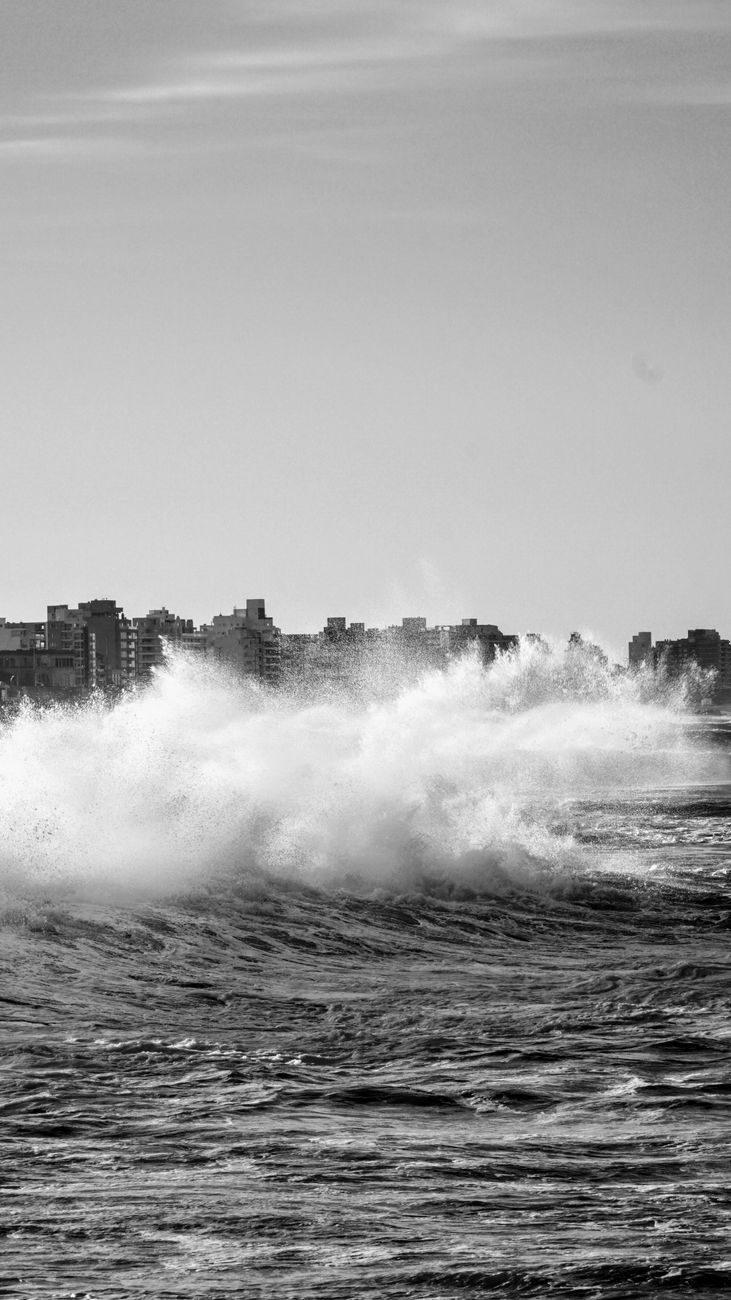 dramatic ocean waves with city skyline