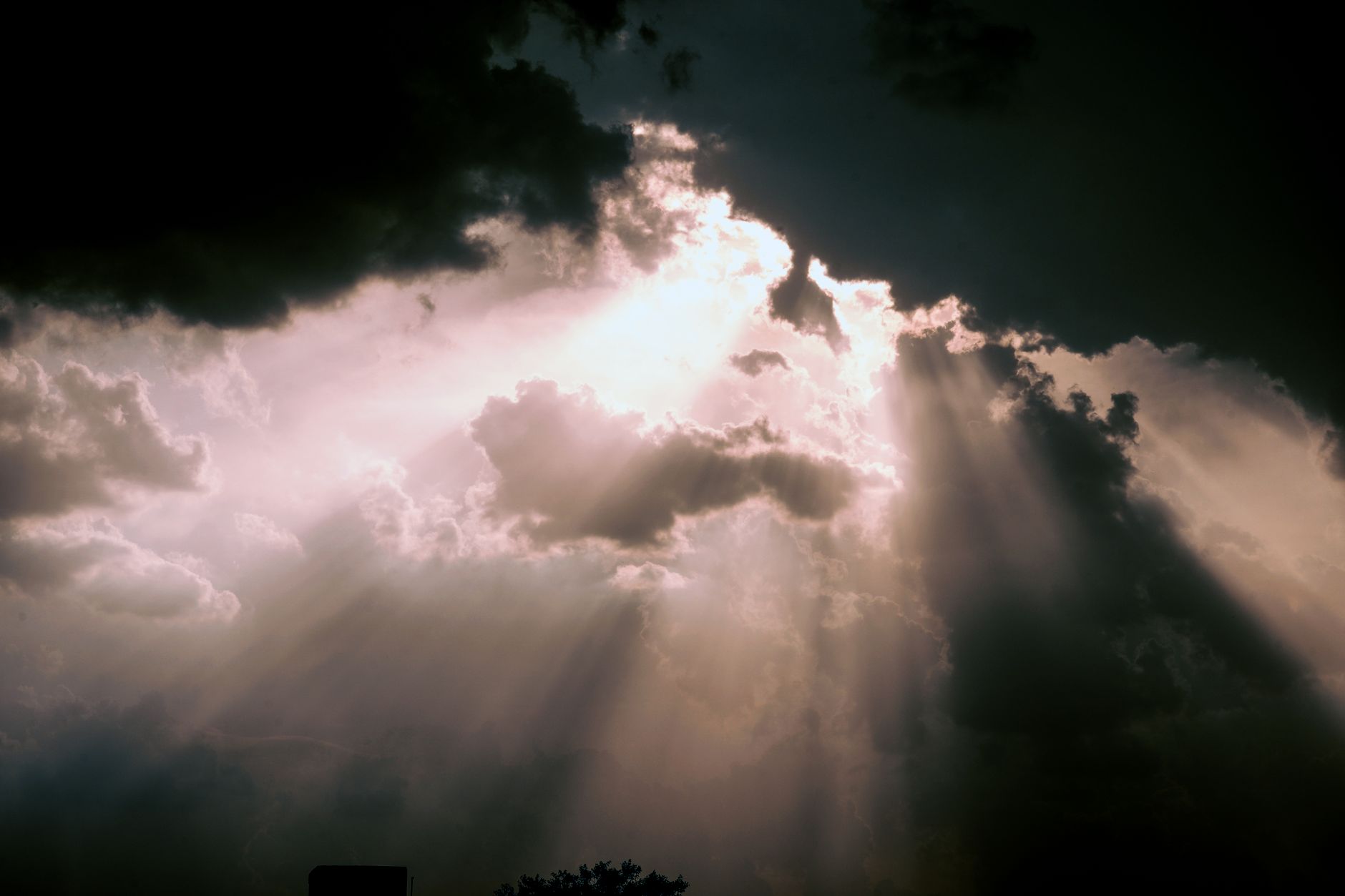 rays of sunlight breaking through dark clouds