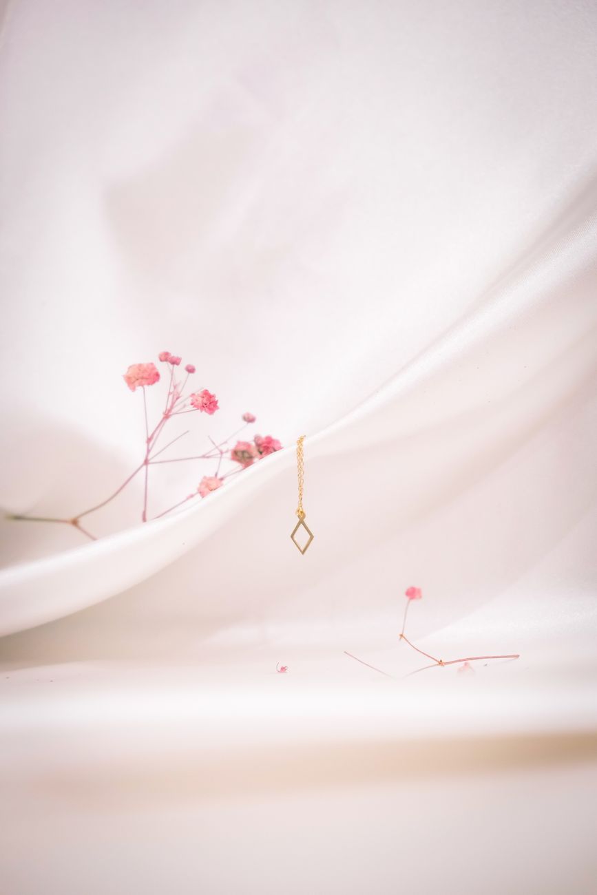 necklace and pink flowers in a studio