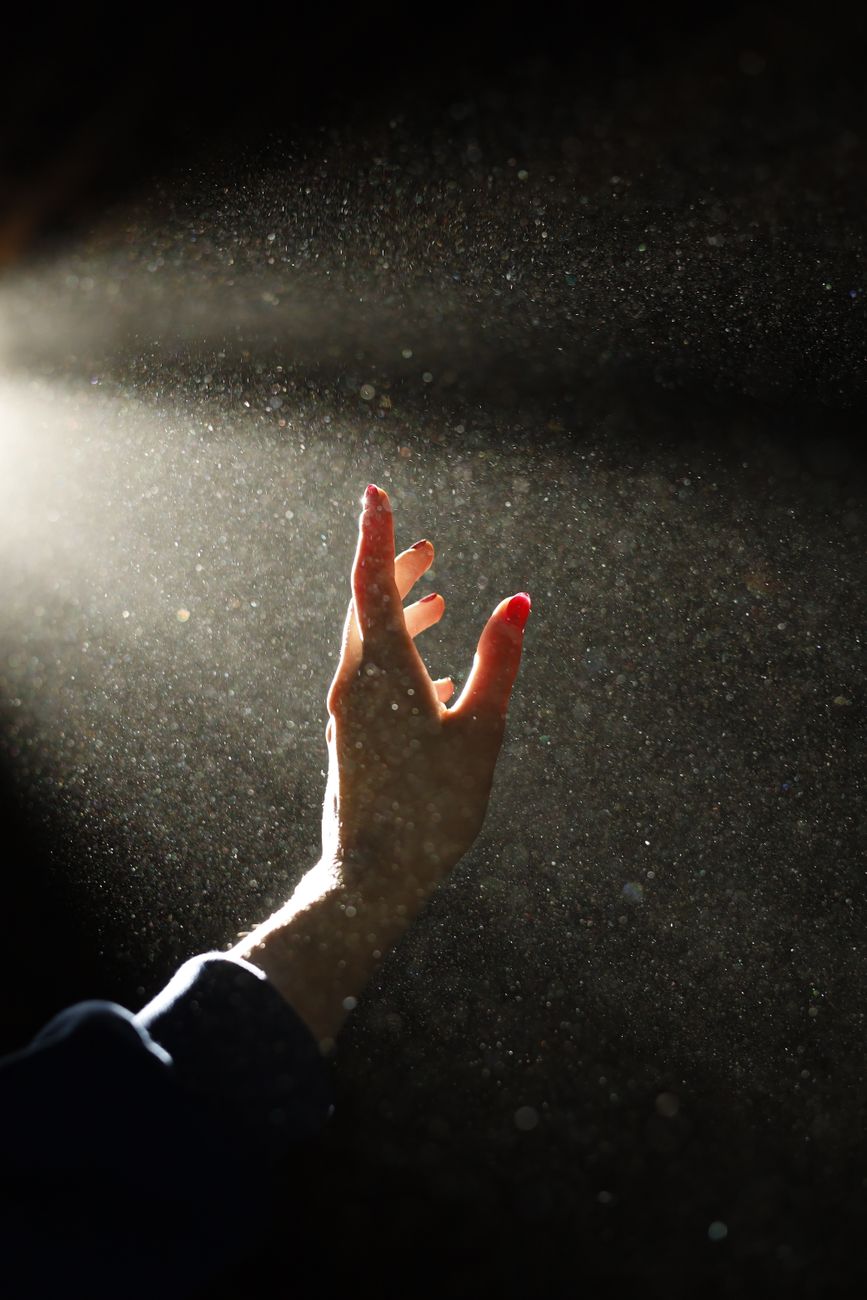 hand reaching for light in dark dusty room