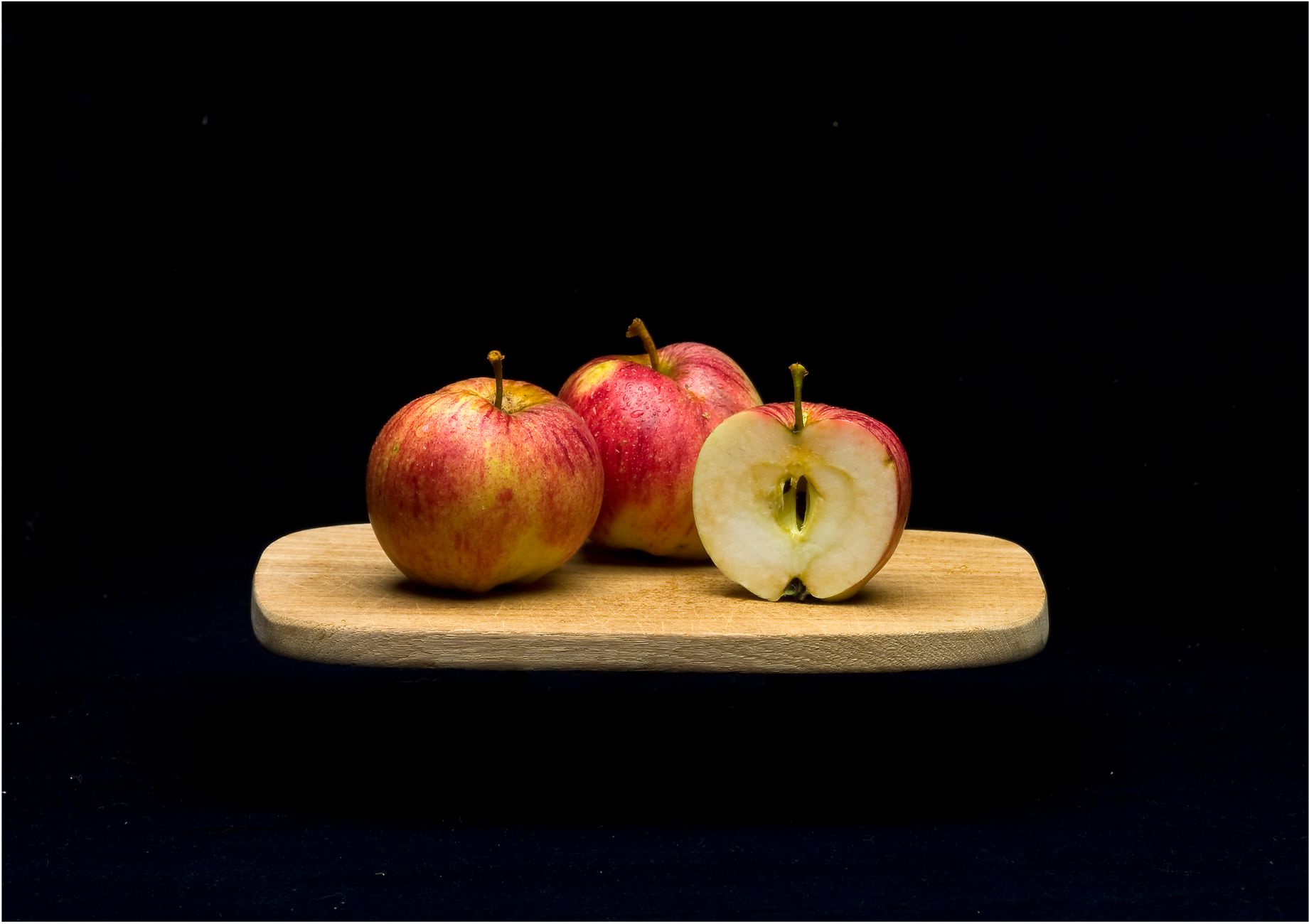 fresh apples on a wooden cutting board