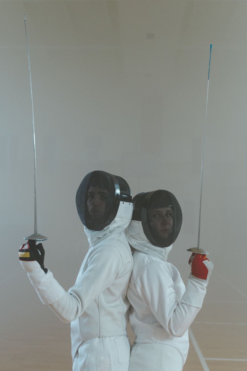man and woman in fencing uniform